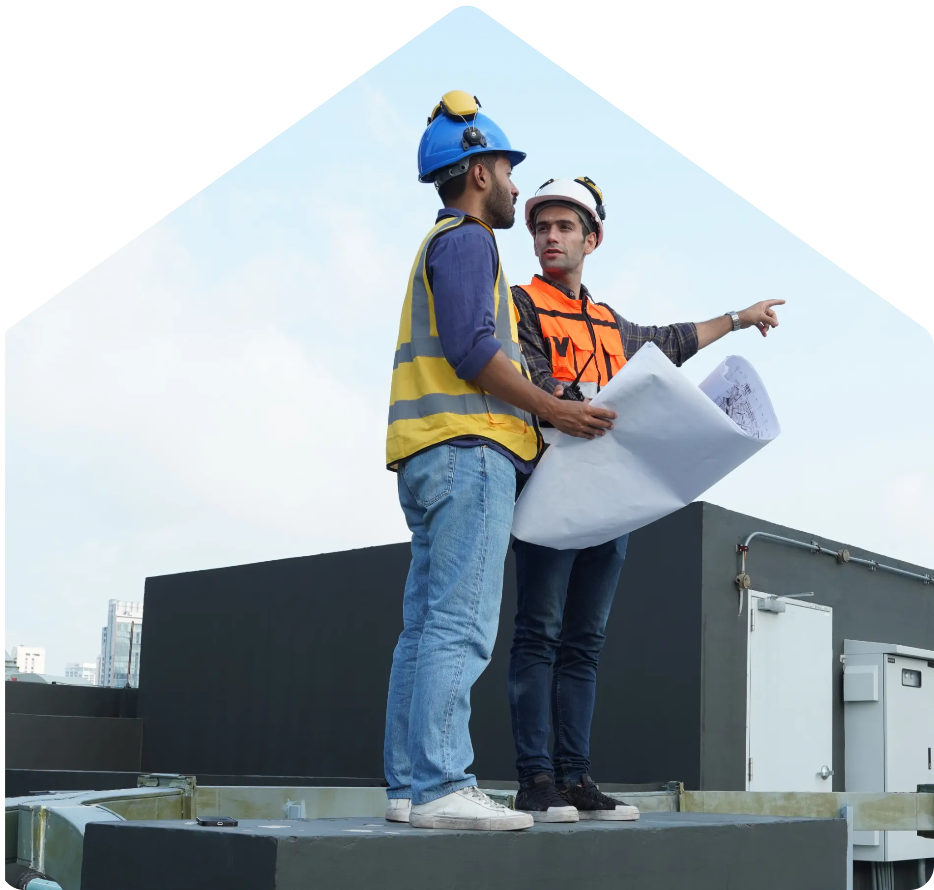 Dos ingenieros revisando planos sobre un techo comercial